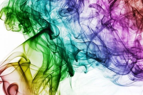 a smoke of rainbow colors in front of a white background